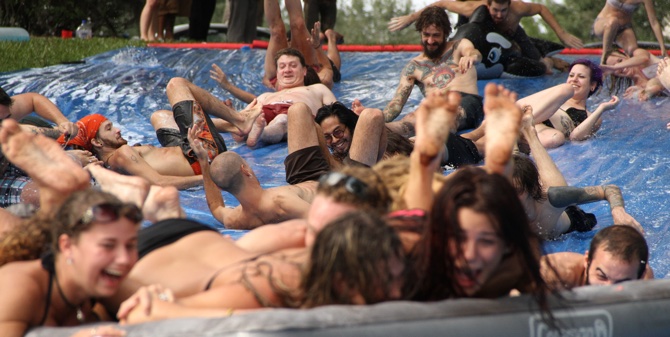 adults on a slip-n-slide smiling and laughing